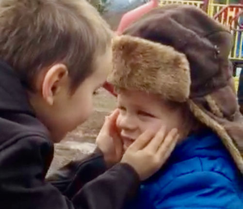 A student connects with his friend who has complex needs, by holding his face