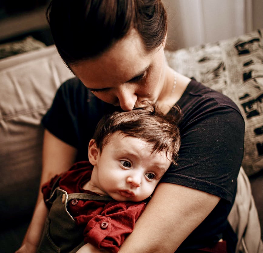 Mama kissing baby in her lap