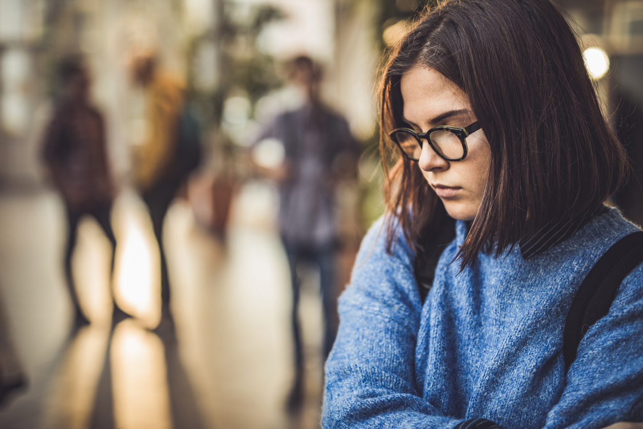 student standing alone in a school hallway