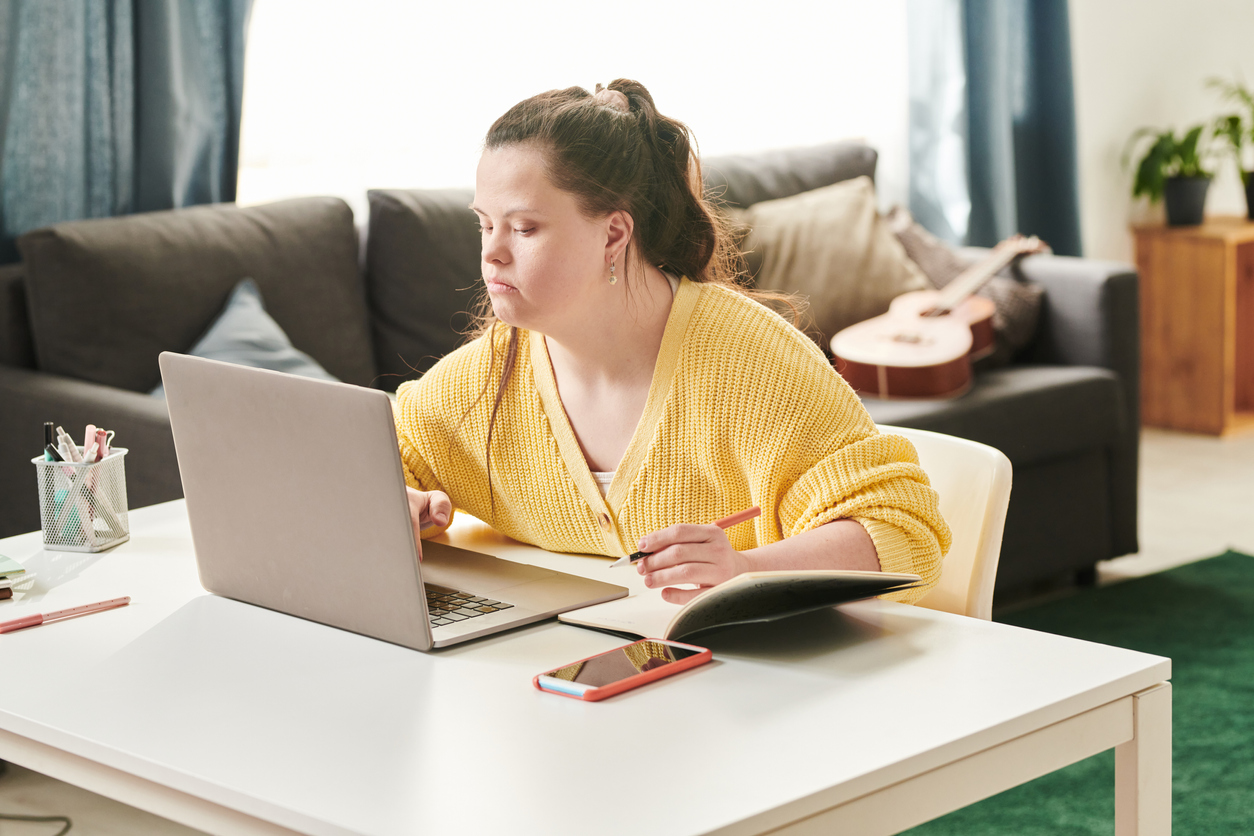 Young woman with Down Syndrome working on a laptop